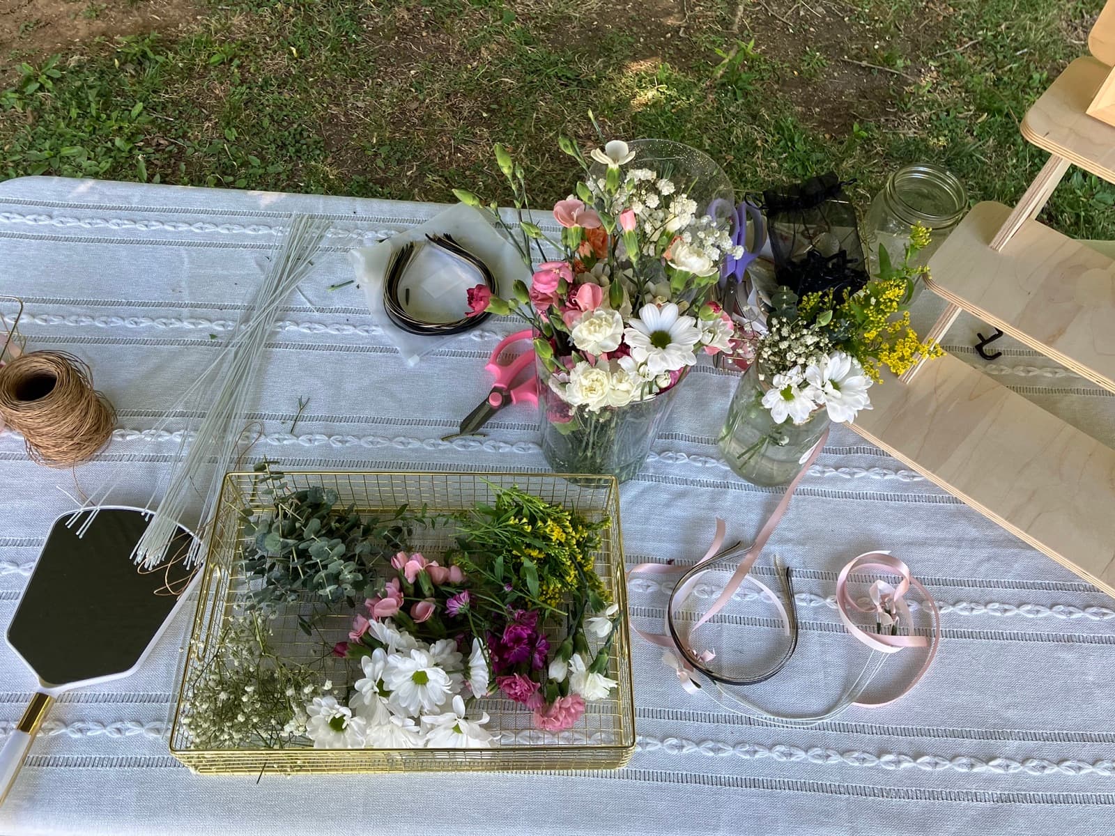 Overhead flat-lay of the flower station setup table — blooms, ribbons, and tools