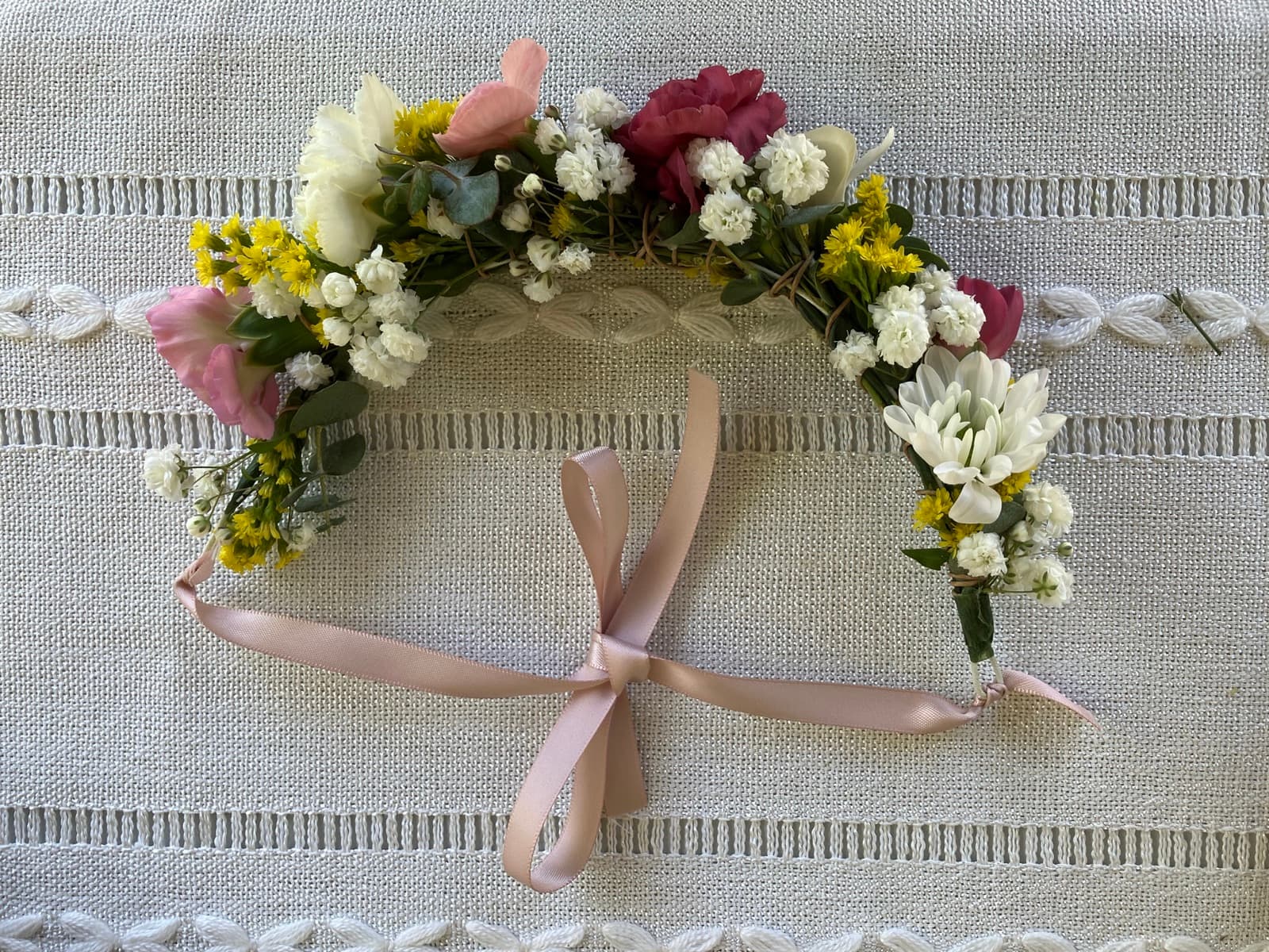 Beautiful completed flower crown with seasonal blooms and soft pink ribbon bow